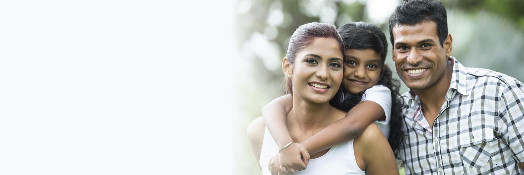 Family of three hugging & smiling l Family dentistry red deer county AB